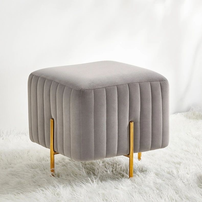 Chic grey velvet ottoman with vertical tufting and gold metal legs