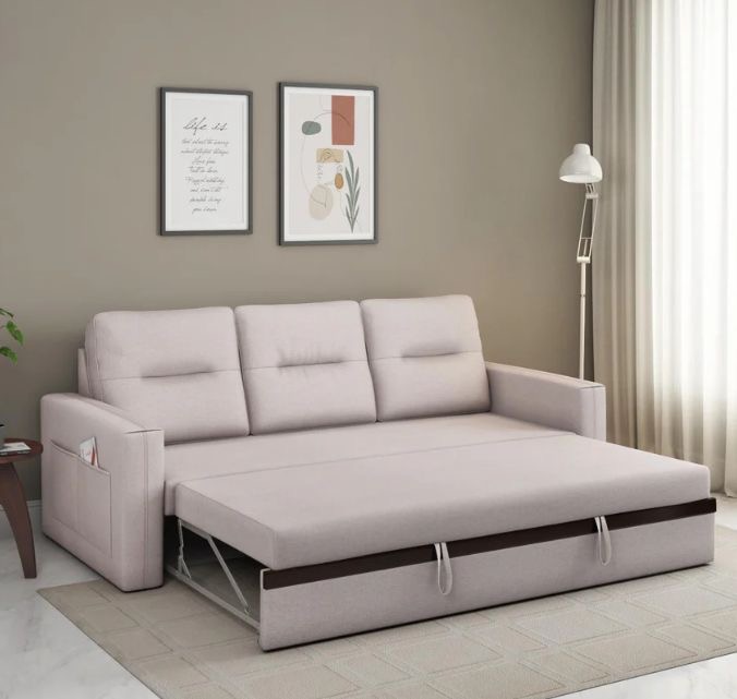 Beige 3 Seater sofa cum bed with pull-out design and side pocket storage in a modern living room