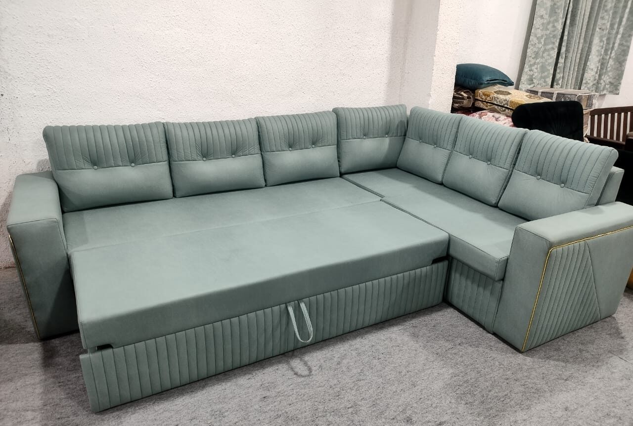 Elegant L-shaped green sofa cum bed with pull-out design and vertical tufted detailing for modern living room