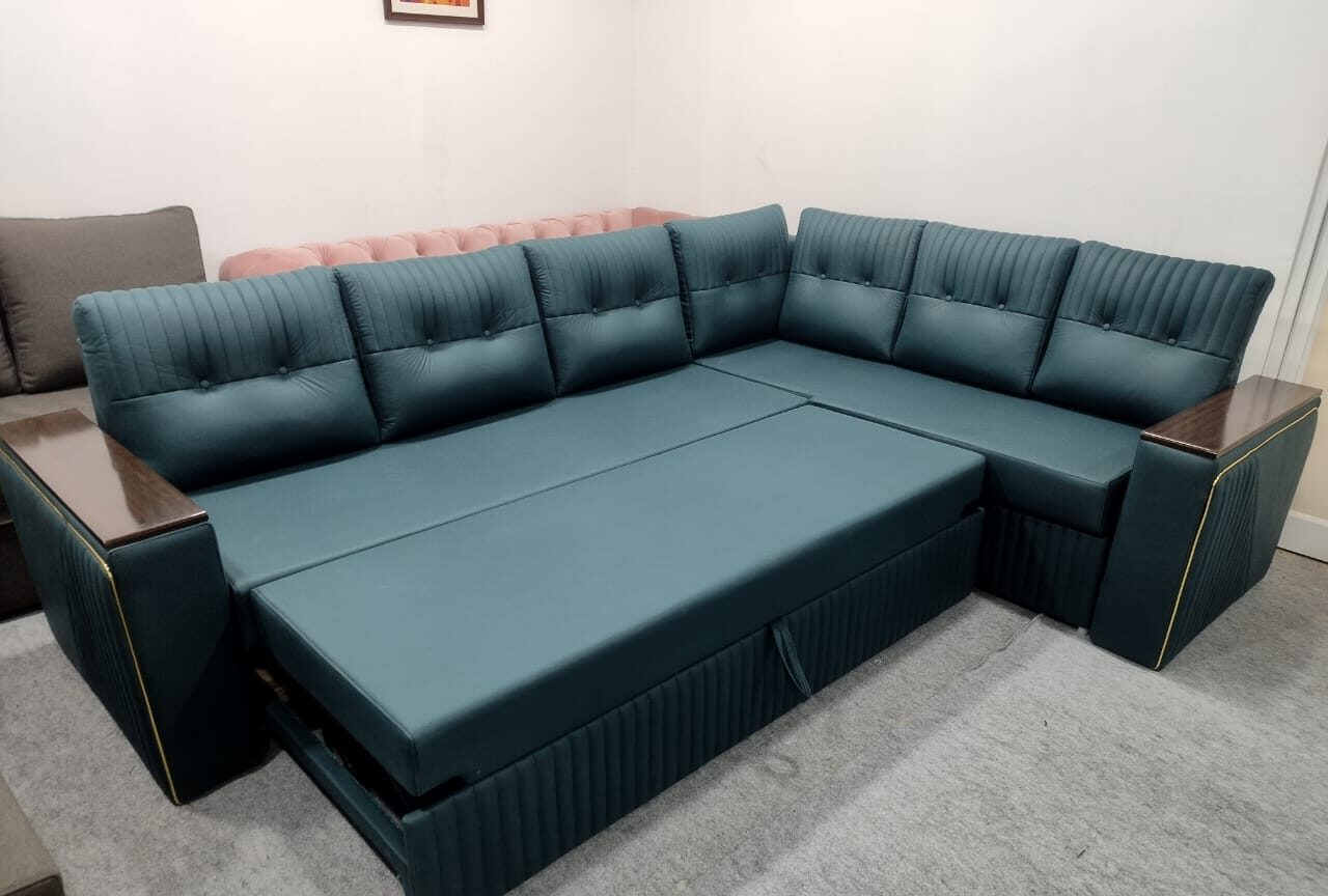 Modern L-shaped teal green sofa cum bed with pull-out mechanism and wooden armrest panels for contemporary living room
